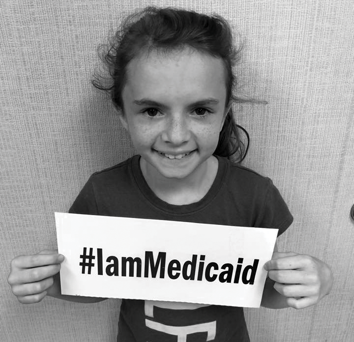 Young girl holding sign reading #IamMedicaid