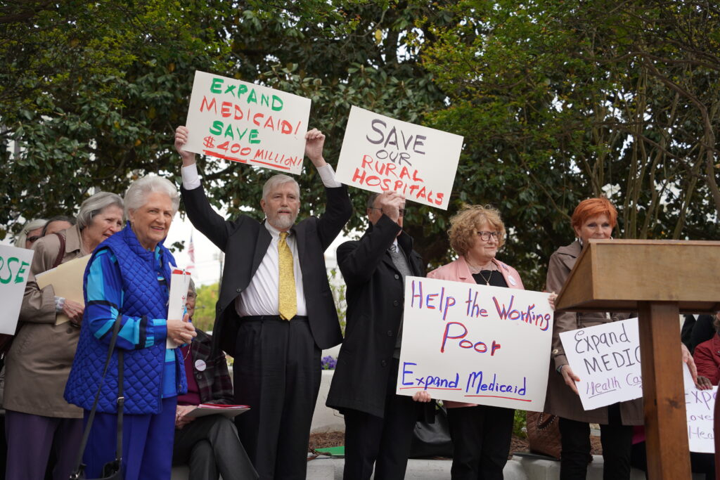 Cover Alabama Lobby Day attendees hold signs showing their support for Medicaid expansion. 